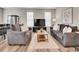 Spacious living room features dual sofas, a central rug, and an entertainment center at 4552 S Perth Ct, Aurora, CO 80015