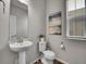 Modern powder room with a pedestal sink, sleek fixtures, and stylish decor at 4552 S Perth Ct, Aurora, CO 80015