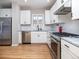 Modern white kitchen with stainless steel appliances and hardwood floors at 636 York St, Denver, CO 80206