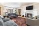 Cozy living room with hardwood floors, sofas, and a fireplace with a TV mounted above at 636 York St, Denver, CO 80206