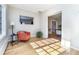 Sunroom with hardwood floors, coral armchair and a view into dining room at 636 York St, Denver, CO 80206