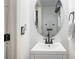 Bathroom featuring a white vanity with a modern oval mirror, complete with dark hardware and towel rack at 15776 E 107Th Way, Commerce City, CO 80022