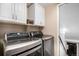 Modern laundry room features a side-by-side washer and dryer set under white cabinets, offering convenience at 15776 E 107Th Way, Commerce City, CO 80022