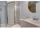 This bathroom features a glass enclosed shower, a round mirror and a sink with a faucet at 265 Cleveland Ct, Bennett, CO 80102