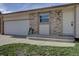 Close-up of the home's entrance with a brick facade, a hose, and a well-lit front door at 265 Cleveland Ct, Bennett, CO 80102