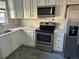 Updated kitchen with stainless steel oven and microwave, quartz countertops, and new white cabinets at 265 Cleveland Ct, Bennett, CO 80102