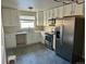 Bright kitchen featuring white cabinets, stainless steel appliances, gray backsplash, and modern finishes at 265 Cleveland Ct, Bennett, CO 80102