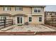 The home features a concrete patio and a sliding glass door entry into the tan siding, two-story home at 5653 Raleigh Cir, Castle Rock, CO 80104