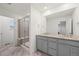 Bathroom featuring a glass shower, a large mirror, and a granite countertop double sink at 9590 Sedalia St, Commerce City, CO 80022