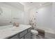 Bathroom with grey cabinetry, white marble countertop, floral shower curtain, and a combined tub and shower at 9590 Sedalia St, Commerce City, CO 80022