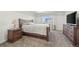 A bedroom featuring a wooden bed frame, two end tables, and a television on a dresser at 9590 Sedalia St, Commerce City, CO 80022