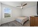 Neutral bedroom with a ceiling fan, a window with blinds, and a dresser next to the wall at 9590 Sedalia St, Commerce City, CO 80022