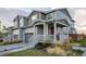 Attractive townhome with a welcoming front porch, gray siding, and well-maintained lawn at 9590 Sedalia St, Commerce City, CO 80022