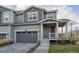 Charming townhome featuring a covered front porch, attached garage, and neutral gray siding at 9590 Sedalia St, Commerce City, CO 80022