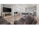 Open-concept living room with a fireplace, large TV, and an adjacent modern kitchen with bar seating at 9590 Sedalia St, Commerce City, CO 80022