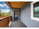 Covered porch with wood ceiling, railing, and a glass door with a blue frame at 192 Little Creek Rd, Idaho Springs, CO 80452