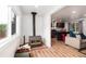 Cozy living room with wood-burning stove, wood floors, and open floorplan to the kitchen at 192 Little Creek Rd, Idaho Springs, CO 80452