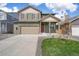 Two-story home featuring a beige garage door, red shutters, and a well-manicured front yard at 769 N Deer Park St, Watkins, CO 80137