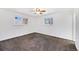 A bright and spacious bedroom with neutral carpet, ceiling fan, and two windows at 8721 E Cornell Dr, Denver, CO 80231
