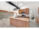 Modern kitchen with wood cabinets, island, and stainless steel appliances at 8721 E Cornell Dr, Denver, CO 80231