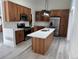 A modern kitchen with stainless steel appliances, light wood cabinets, and a center island at 8721 E Cornell Dr, Denver, CO 80231
