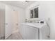 Functional laundry room with modern washer and dryer and access to bath at 8721 E Cornell Dr, Denver, CO 80231
