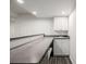 Basement bar features sleek countertops, white cabinetry, modern fixtures and stylish flooring perfect for gatherings at 5977 S Rock Creek Dr, Castle Rock, CO 80109