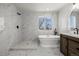 Updated bathroom featuring a soaking tub, walk-in shower, and modern vanity with dark hardware at 5977 S Rock Creek Dr, Castle Rock, CO 80109