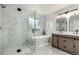 Bright bathroom features a glass shower, soaking tub and double sink vanity with marble tile surround at 5977 S Rock Creek Dr, Castle Rock, CO 80109