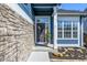 Close up of front door with stylish stone accent wall, and well-manicured landscaping with rocks at 5977 S Rock Creek Dr, Castle Rock, CO 80109
