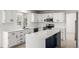 Modern kitchen featuring white cabinets, subway tile backsplash, stainless steel appliances and a center island at 5977 S Rock Creek Dr, Castle Rock, CO 80109