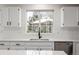 Kitchen sink overlooking large window with white cabinets, black hardware and subway tile backsplash at 5977 S Rock Creek Dr, Castle Rock, CO 80109