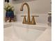 Close up of modern bathroom vanity with gold faucet, white countertop and sink at 1250 S Monaco Pkwy # 17, Denver, CO 80224