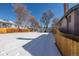 Spacious, snow-covered backyard with detached garage, enhanced by a wooden fence for privacy and security at 2918 Ames St, Wheat Ridge, CO 80214