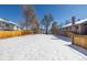 Large, snow-covered backyard features a detached garage and privacy fence, offering ample space for outdoor activities at 2918 Ames St, Wheat Ridge, CO 80214