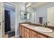 Blue bathroom with double vanity sinks, framed mirrors, and a shower-tub combo at 10774 Chadsworth Ln, Highlands Ranch, CO 80126