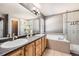 Well-lit bathroom featuring a double sink vanity, soaking tub, and glass-enclosed shower at 10774 Chadsworth Ln, Highlands Ranch, CO 80126