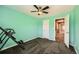 A spacious room with mint green walls and carpeted floors features a ceiling fan and window at 10774 Chadsworth Ln, Highlands Ranch, CO 80126