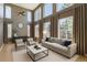 Bright living room featuring tall windows, neutral decor, and a cozy seating arrangement at 10774 Chadsworth Ln, Highlands Ranch, CO 80126