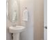 Close up of a half bathroom featuring a pedestal sink, mirror, and towel rack at 13275 E Caley Pl, Centennial, CO 80111