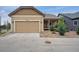 Charming home featuring a tan exterior, well-kept landscaping, and a convenient two-car garage at 13275 E Caley Pl, Centennial, CO 80111
