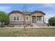 Charming single-story home with a welcoming front porch and nicely landscaped front yard on a sunny day at 13275 E Caley Pl, Centennial, CO 80111