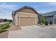 Exterior view of a well-maintained garage with tan siding and landscaping at 13275 E Caley Pl, Centennial, CO 80111