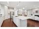 Open concept kitchen featuring a large island with a sink, stainless steel refrigerator, and modern white cabinets at 13275 E Caley Pl, Centennial, CO 80111