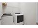 Efficient laundry room with modern white appliances and overhead shelving at 13275 E Caley Pl, Centennial, CO 80111