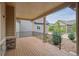 Inviting covered porch with wood flooring, stone accents, and black railings, offering a cozy outdoor space at 13275 E Caley Pl, Centennial, CO 80111