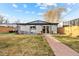 Well-maintained backyard with a stone walkway, inviting lawn, and a private fence at 4510 W 4Th Ave, Denver, CO 80219