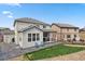 Backyard view featuring a covered patio with outdoor seating, grassy area, and fencing for privacy at 4830 S Versailles St, Aurora, CO 80015