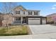 Inviting two-story home with a three-car garage, covered porch, and well-manicured front yard at 4830 S Versailles St, Aurora, CO 80015