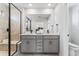 Stylish bathroom with a double vanity, quartz countertop, black hardware, and a glass enclosed shower at 2087 Generations Aly, Brighton, CO 80601